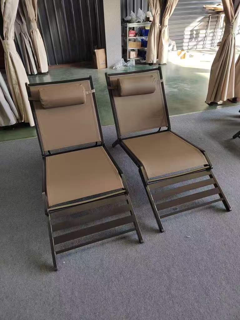 Two beige lounge chairs with metal frames, ideal for relaxation. perfect for outdoor or indoor use.